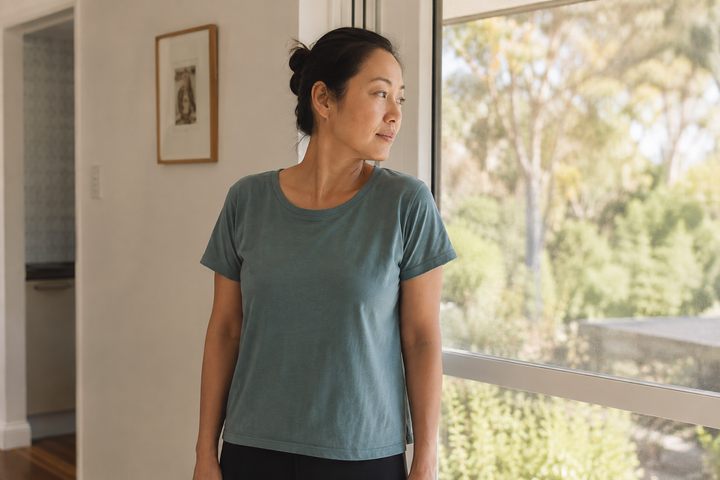 Woman gently turning her head during a quiet break beside a sunlit window